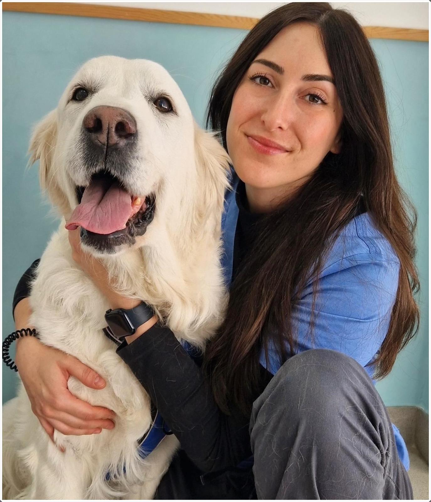 Veterinaria de Viñas Viejas abrazando a un golden retriever en la consulta